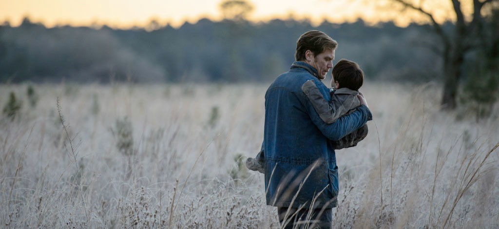 Entretien avec Jeff Nichols : scène où le père (Michael Shannon) porte l'enfant (Jaeden Lieberher) dans un champs - Midnight Special